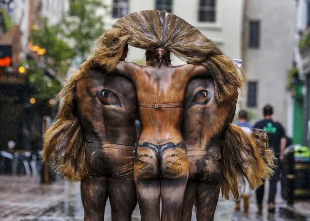 Hand-painted models depicting a lion's head, pose for photographers during a photo-op in central London's Carnaby Street, on June 3, 2014. It was part of events marking the opening of the Zoological Society of London's first ever pop-up shop on the famous street, part of the Lions400 campaign to expose the plight of the endangered Asian lion. (Photo by Lefteris Pitarakis/Associated Press)
