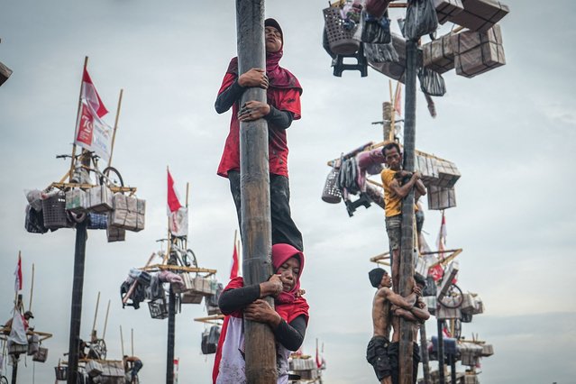 Women participate in a traditional game called “Panjat Pinang” to climb a 4-meter-high tree pole smeared with oil to collect prizes at the top as part of the annual celebration of Indonesia's 79th Independence Day in Palembang, South Sumatra, on August 18, 2024. (Photo by Al Zulkifli/AFP Photo)