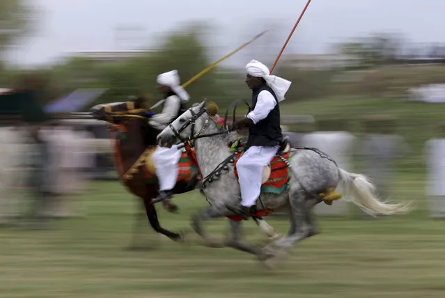Pakistani riders proceed to their targets during competition organized by the Pakistan Tent Pegging Association in Islamabad, Pakistan, Friday, April 21, 2017. In tent pegging, a horseman gallops and uses a sword or a lance to pierce, pick up, and carry away a wooden peg. (Photo by B.K. Bangash/AP Photo)