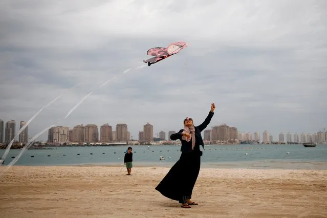 A Muslim woman flies a kite at Katara beach in Doha, Qatar on December 13, 2019. (Photo by Corinna Kern/Reuters)