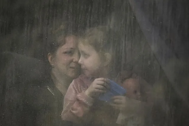 A mother with her daughter sit inside a bus as they evacuate the city of Bakhmut at the eastern Ukranian region of Donbas on May 22, 2022, amid Russian invasion of Ukraine. (Photo by Aris Messinis/AFP Photo)