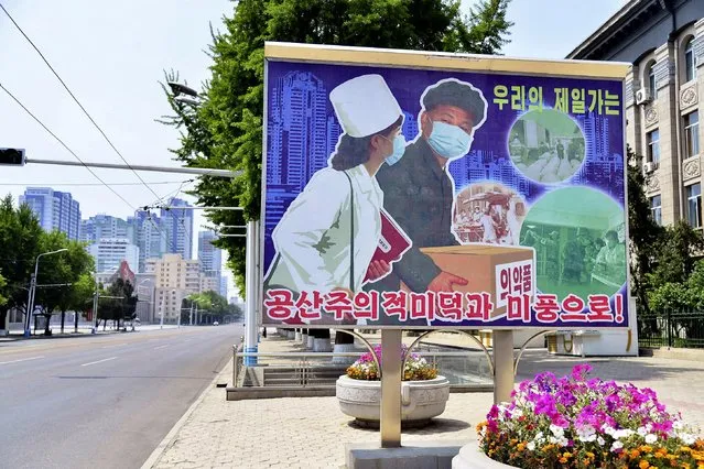 A sign depicting a scene of medical products transportation is displayed at the empty street, amid growing fears over the spread of coronavirus disease (COVID-19), in Pyongyang, North Korea, in this photo released by Kyodo on May 23, 2022. (Photo by Kyodo News via Reuters)