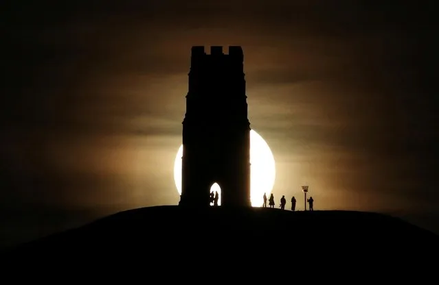 St Michael's Tower is seen on Glastonbury Tor as a full moon rises in Glastonbury, England on January 10, 2020. (Photo by Peter Cziborra/Reuters)