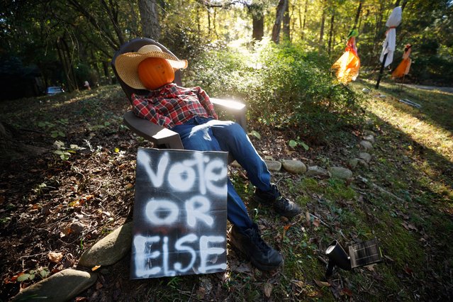 A hand-painted sign encouraging citizens to vote, sits with Halloween decorations in the front yard of a home in Chapel Hill, North Carolina, U.S. October 20, 2024. (Photo by Jonathan Drake/Reuters)