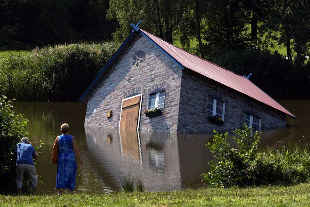 A “sunken” house is seen in the pond of the Kunsthalle Rostock museum in Rostock, Germany,  August 1, 2014. The installation “Atlantis” by Finnish artist Tea Maekkipaeae has been set up in the pond on July 31. It is part of the exhibiton “Nature and More” with contemporary artists from Finnland which will run until September 14, 2014. (Photo by Bernd Wuestneck/EPA)