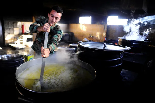 A new Syrian army recruit prepares food for the Iftar (breaking fast) meal, at a military training camp in Damascus, Syria June 26, 2016. Picture taken June 26, 2016. (Photo by Omar Sanadiki/Reuters)