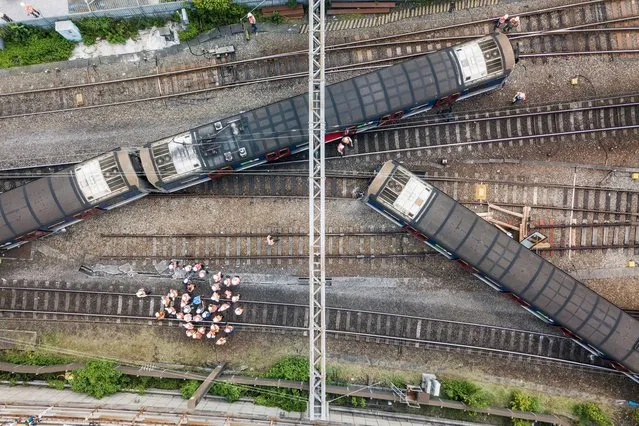 This aerial picture shows rescue workers standing on a railway track near a passenger train, after it derailed during rush hour outside Hung Hom station on the Kowloon side of Hong Kong on September 17, 2019. A passenger train derailed during the morning rush hour in Hong Kong on September 17 leaving three people injured, authorities said. (Photo by Anthony Wallace/AFP Photo)