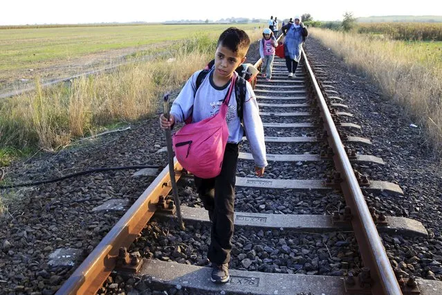 A migrant boy walks on a railway track after he crossed the Hungarian-Serbian border near Roszke, Hungary August 27, 2015. (Photo by Bernadett Szabo/Reuters)