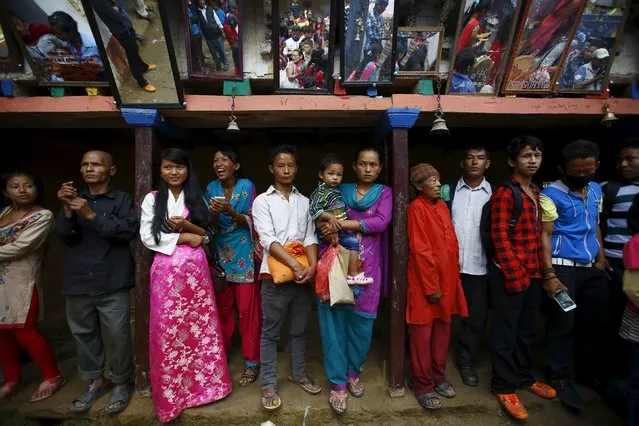 People gather as they watch shamans perform religious rituals during the “Janai Purnima” festival (Sacred Thread Festival) at Timal Village in Kavre, Nepal, August 29, 2015. (Photo by Navesh Chitrakar/Reuters)