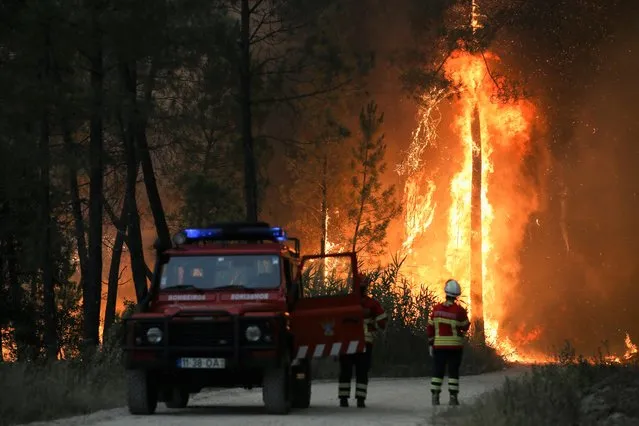 Firefighters watch a wildfire in Ourem, Santarem district, Portugal on July 12, 2022. (Photo by Rodrigo Antunes /Reuters)