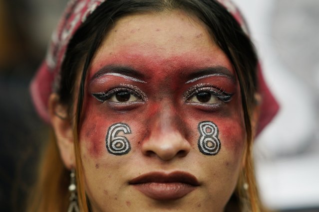 A woman with the number 68 painted on her face participates in a march in remembrance of the 1968 Tlatelolco student massacre in Mexico City, Monday, October 2. 2023. (Photo by Eduardo Verdugo/AP Photo)