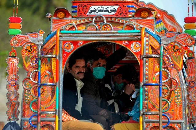 Residents wearing facemasks as a preventive measure against the spread of the COVID-19 coronavirus sit in a passenger pick-up on a street in Rawalpindi on March 13, 2020. (Photo by Aamir Qureshi/AFP Photo)