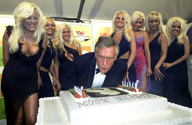 Hugh Hefner leans over a giant birthday cake as he blows out candles to celebrate his 75th birthday, 2001. (Photo by Reuters/Stringer .)