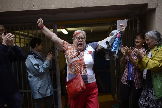 A woman celebrates outside a polling station after casting her vote in Barcelona, on October 01, 2017, in a referendum on independence for Catalonia banned by Madrid. Madrid has vowed to stop the referendum from going ahead, closing polling stations, seizing millions of ballot papers, detaining key organisers and shutting down websites promoting the vote. (Photo by Josep Lago/AFP Photo)