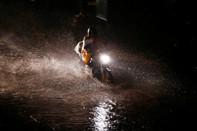 A motorcyclist wades through a waterlogged street during rains in New Delhi, India August 1, 2016. (Photo by Adnan Abidi/Reuters)