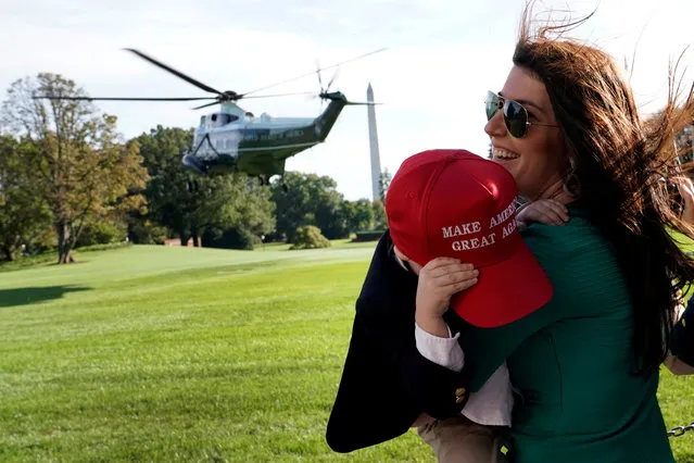 Megan Sanders and her son John, 4, react to wind as Marine One helicopter with U.S. President Donald Trump on board departs from the White House in Washington, U.S., en route Greer, South Carolina, October 16, 2017. (Photo by Yuri Gripas/Reuters)