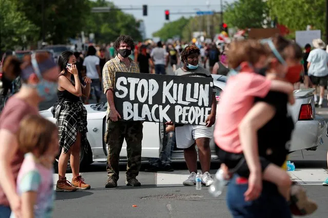 Protesters gather at the scene where George Floyd, an unarmed black man, was pinned down by a police officer kneeling on his neck before later dying in hospital in Minneapolis, Minnesota, U.S. May 26, 2020. (Photo by Eric Miller/Reuters)