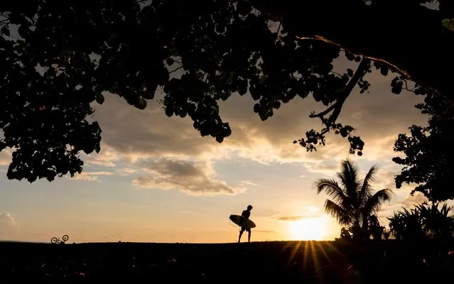 A surfer holds a board at the Orofara surfing spot near Mahina, on April 30, 2020, on the second day of esaing of restrictions to stop the spread of the novel coronavirus, COVID-19. Beaches and surf spots were crowded on April 29, the first official day for the easing of restrictions to stop the spread of the novel coronavirus, COVID-19 decided by the high commissioner of Polynesia, well before French mainland. But several measures remain, such as the suspension of air rotations, barrier gestures, or the closure of schools, at least until May 18. (Photo by Suliane Favennec/AFP Photo)