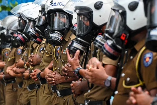 Policemen stand guard during a demonstration by the university students in Colombo on August 18, 2022. (Photo by Ishara S. Kodikara/AFP Photo)