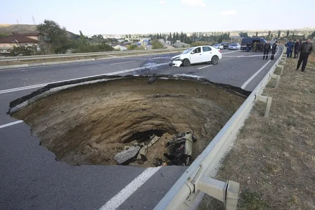 A car lies in a sinkhole in the road outside the Crimean capital Simferopol, September 28, 2014.A sinkhole about eight meters wide and deep opened up on Saturday night on the road between Nikolayev and Yevpatoria highway; killing six people tavelling in a car which fell into the pit, according to local media. (Photo by Pavel Rebrov/Reuters)
