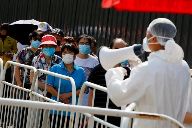People line up to receive nucleic acid tests at a temporary testing site after a new outbreak of the coronavirus disease (COVID-19) in Beijing, China on June 30, 2020. (Photo by Thomas Peter/Reuters)