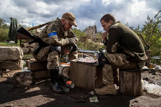 Ukrainian service members play checkers at a position near a frontline, amid Russia's attack on Ukraine, in Kharkiv region, Ukraine on September 24, 2022. (Photo by Oleksandr Ratushniak/Reuters)