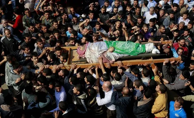 Palestinian mourners carry the body of Hamas' top military commander, Ahmed Jabari, killed in an Israeli strike on Wednesday, during his funeral in Gaza City on Thursday. (Photo by Adel Hana/Associated Press)