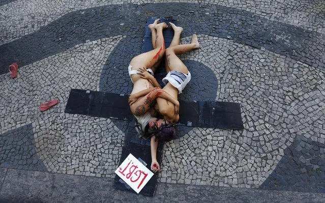 Activists kiss during a demonstration “against homophobia” outside Candelaria church in Rio de Janeiro October 4, 2014. (Photo by Ricardo Moraes/Reuters)