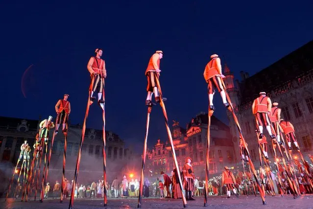 Stilt walkers wearing medieval costumes perform during an annual Renaissance pageant, the Ommegang parade, which commemorates the 16th century arrival of Habsburg Emperor Charles V, on Brussels Grand Place, Belgium, July 3, 2014. (Photo by Eric Vidal/Reuters)