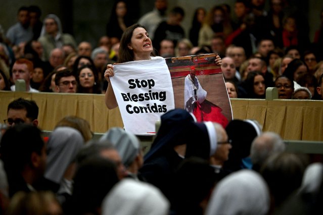 A Peta animal rights activist holds a slogan which reads “stop blessing corridas” referring to bullfighting, as Pope Francis presides the vespers, on the solemnity of the conversion of Saint Paul, in the Basilica of St. Paul Outside The Walls in Rome on January 25, 2024. (Photo by Filippo Monteforte/AFP Photo)