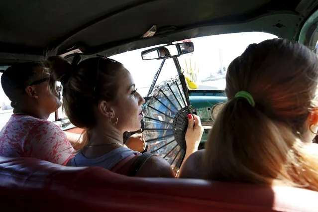 A woman fans herself while riding in a taxi in Havana, Cuba September 19, 2015. (Photo by Carlos Garcia Rawlins/Reuters)