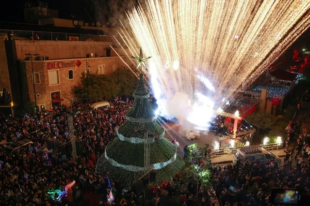People gather during a Christmas tree lighting ceremony in Byblos, Lebanon on December 8, 2022. (Photo by Mohamed Azakir/Reuters)