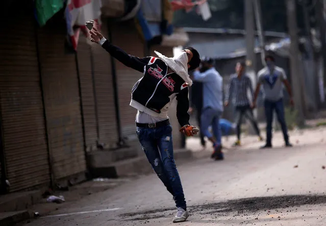 A protester throws a stone towards Indian police during a protest against the recent killings in Kashmir, in Srinagar September 13, 2016. (Photo by Danish Ismail/Reuters)