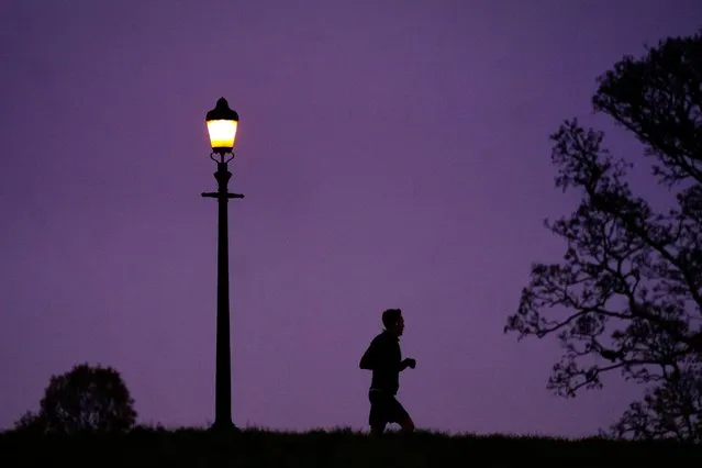 A man jogging during misty weather in Primrose Hill, London on Friday, December 9, 2022. Parts of the UK are being hit by freezing conditions with the UK Health Security Agency (UKHSA) issuing a Level 3 cold weather alert covering England until Monday and the Met Office issuing several yellow weather warnings for snow and ice in parts of the UK over the coming days. (Photo by Victoria Jones/PA Images via Getty Images)