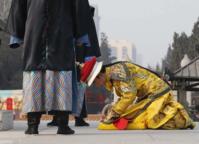 A performer dressed as a Qing dynasty emperor bows while he prays in an ancient Qing Dynasty ceremony, in which emperors prayed for good harvest and fortune, during the temple fair at Ditan Park, also known as the Temple of Earth, in Beijing February 9, 2013. The Lunar New Year, or Spring Festival, begins on February 10 and marks the start of the Year of the Snake, according to the Chinese zodiac.  (Photo by Kim Kyung-Hoon/Reuters)