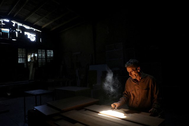 A carpenter works following a power outage at a carpentry workshop in Tehran, Iran, on June 1, 2025. (Photo by Majid Asgaripour/WANA (West Asia News Agency) via Reuters)