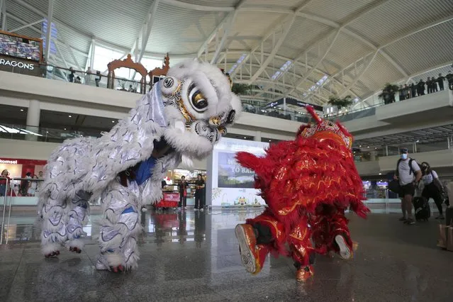 Lion dancers welcome Chinese tourists on their arrival at the Ngurah Rai international airport in Bali, Indonesia on Sunday, January 22, 2023. A direct flight from China landed in Indonesia's resort island of Bali for the first time on Sunday in nearly three years after the route was cancelled due to the pandemic. At least 210 people were on board a chartered plane operated by Indonesia's Lion Air from Shenzhen in China's southern Guangdong province to Bali's international airport. (Photo by Firdia Lisnawati/AP Photo)