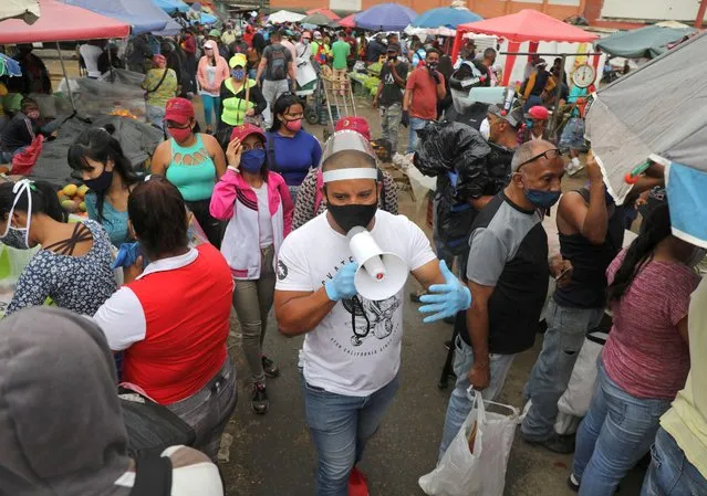 Walter Rivera, director of the Coche wholesale market shouts the rules to prevent the coronavirus (COVID-19) disease to sellers and customers amid the outbreak in Caracas, Venezuela on July 23, 2020. (Photo by Manaure Quintero/Reuters)