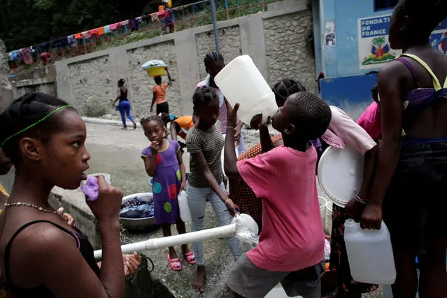 A boy drinks drinkable water from a container at a source in Port-au-Prince, Haiti, September 7, 2016. Picture taken September 7, 2016. (Photo by Andres Martinez Casares/Reuters)
