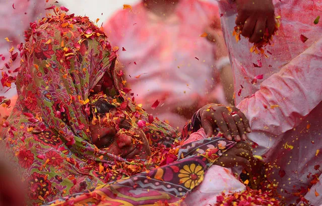 Flower petals and coloured powder is thrown around at an event to celebrate the Hindu festival of Holi for children with cerebral palsy organized by the Trishla Foundation in Allahabad on February 25, 2018. (Photo by Sanjay Kanojia/AFP Photo)