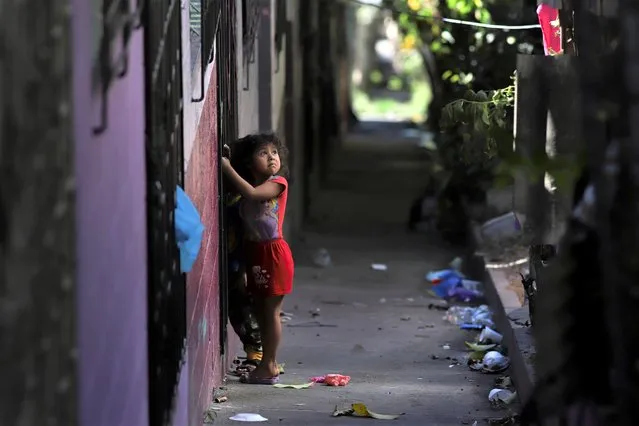 A girl stands near her house dismantled by members of the Barrio 18 Gang in La Campanera neighborhood of Soyapango, El Salvador, Friday, January 27, 2023. At least five hundred houses were dismantled by members of the Barrio 18 gang and used for consumption and drug trafficking, expelling their owners. (Photo by Salvador Melendez/AP Photo)