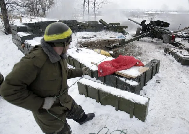 A Ukrainian serviceman fires a cannon positioned close to the airport in the eastern Ukranian city of Donetsk on December 2, 2014. Ukraine and pro-Russian separatists agreed Tuesday to a truce at Donetsk airport – ground zero in a war that has killed more than 4,000 people – as well as across a wider swathe of rebel-held territory. (Photo by Anatolii Stepanov/AFP Photo)