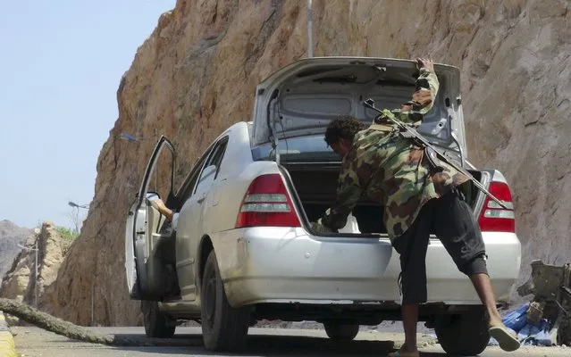 A militant loyal to Yemen's government searches a car at a checkpoint in the country's southern port city of Aden October 19, 2015. (Photo by Reuters/Stringer)