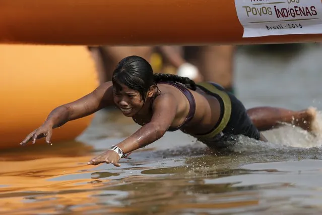 An indigenous woman from Gaviao tribe jumps into the water on her way to winning a swimming competition during the first World Games for Indigenous Peoples in Palmas, Brazil, October 30, 2015. (Photo by Ueslei Marcelino/Reuters)