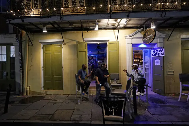 Patrons resume their socializing at Cuban Creations Cigar Bar in the French Quarter in New Orleans, after power was restored Wednesday, October 28, 2020. Hurricane Zeta passed through earlier Wednesday, leaving much of the city and metro area without power. (Photo by Gerald Herbert/AP Photo)