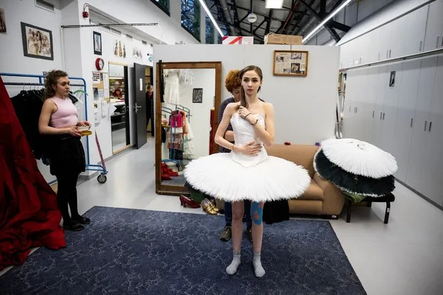 A seamstress adjusts the stage dress of Ganna Muromtseva, 29, a professional ballerina from Ukraine who fled her country after Russia’s invasion, for the Swan Lake ballet at Eiffel Art Studios in Budapest, Hungary, February 23, 2023. Muromtseva left Ukraine with just a bag when she was at the peak of her career at the National Opera of Ukraine, and after a year of trying to survive from one day to another and rebuilding herself as a dancer physically and mentally, she is now back at the top with the role of the White Swan and the Black Swan, which she had danced for more than five years as part of her Ukraine company in Kyiv, China and Tokyo before. “I'm happy to make a story on stage again”, she said. “It is a totally different production (in Budapest), for me it feels like I really have to prove ... You have to be...very flexible in your head, not (just) in your body”. (Photo by Marton Monus/Reuters)