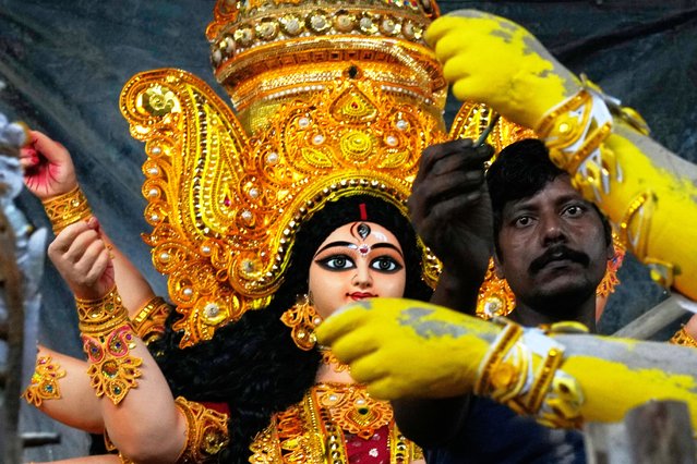 An artisan gives finishing touches to an idol of Hindu goddess Durga at a workshop amid Durga Puja festivities in Mumbai, India, Friday, September 26, 2025. (Photo by Rajanish Kakade/AP Photo)