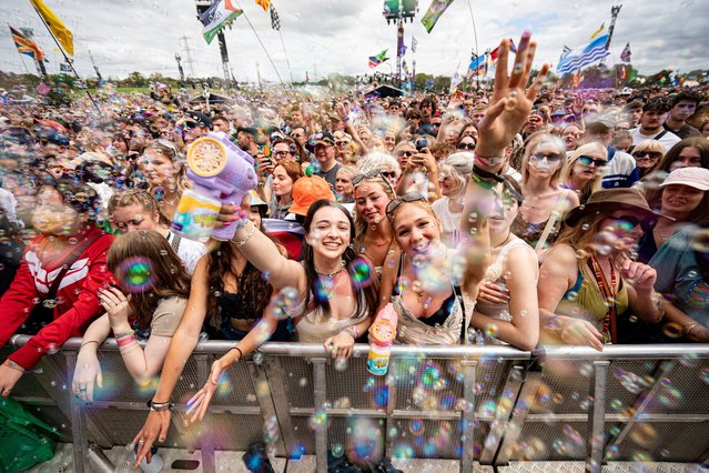 Music fans blow bubbles as they watch ferstival acts on the pyramid stage at Glastonbury Festival at Worthy Farm in Somerset, UK on Friday, June 28, 2024. (Photo by Ben Birchall/PA Images via Getty Images)