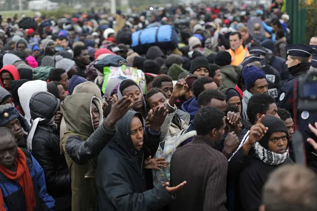 Migrants line-up to register at a processing centre in the makeshift migrant camp known as “the jungle” near Calais, northern France, Monday October 24, 2016. French authorities are beginning a complex operation, unprecedented in Europe, to shut down the makeshift camp, uprooting thousands who made treacherous journeys to escape wars, dictators or grinding poverty and dreamed of making a life in Britain. (Photo by Emilio Morenatti/AP Photo)