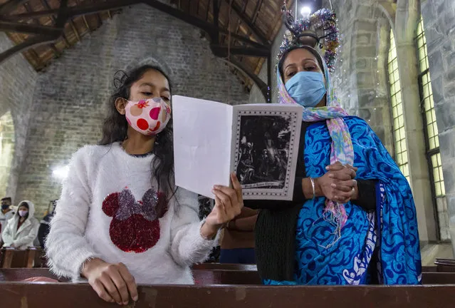 Indian Christians, who are registered members of St. John in the Wilderness church, attend the Christmas mass in Dharmsala, India, Friday, December 25, 2020. The church which was built in 1852, is currently closed to general visitors due to COVID-19 restrictions. (Photo by Ashwini Bhatia/AP Photo)